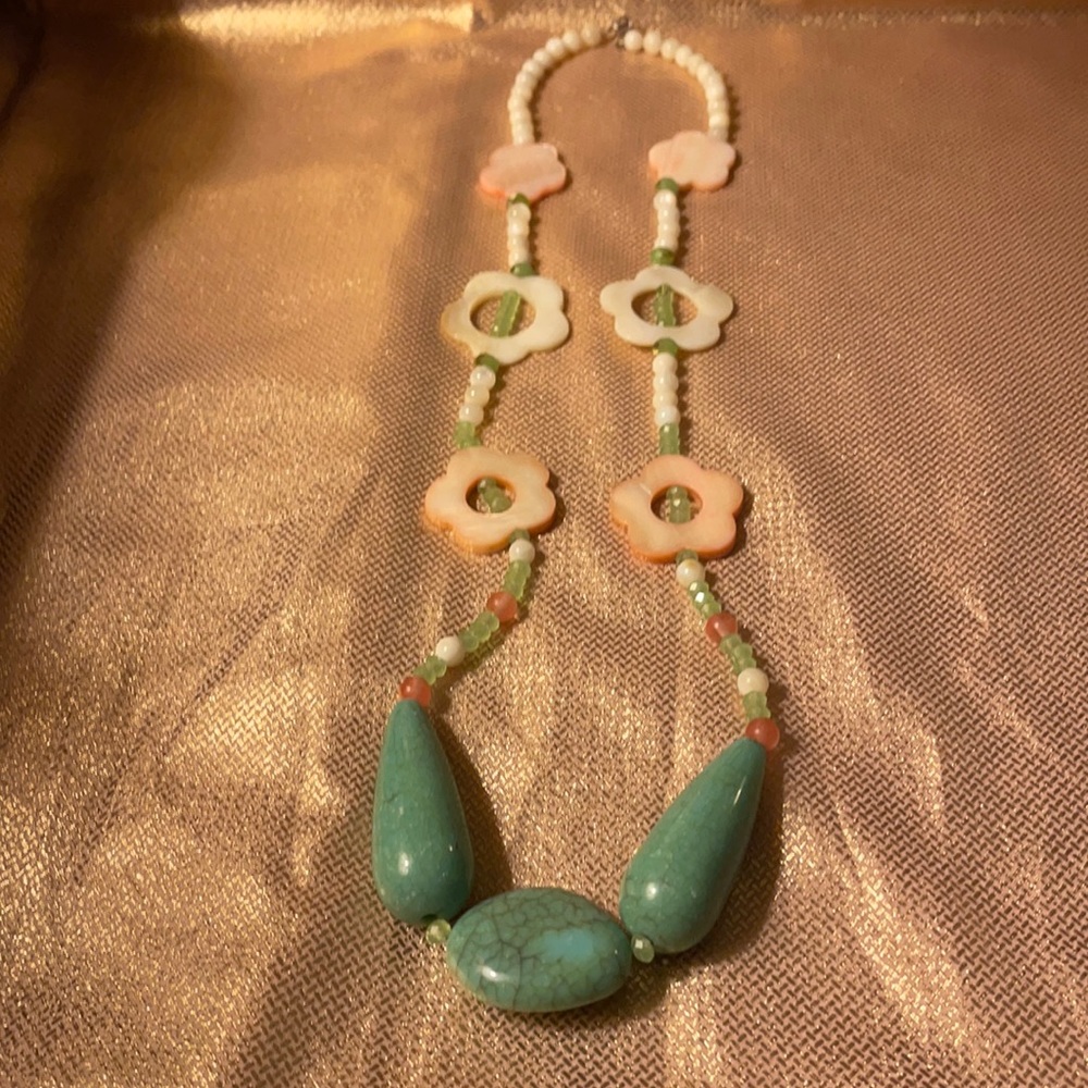 Necklace with shell look flowers and blue stones.